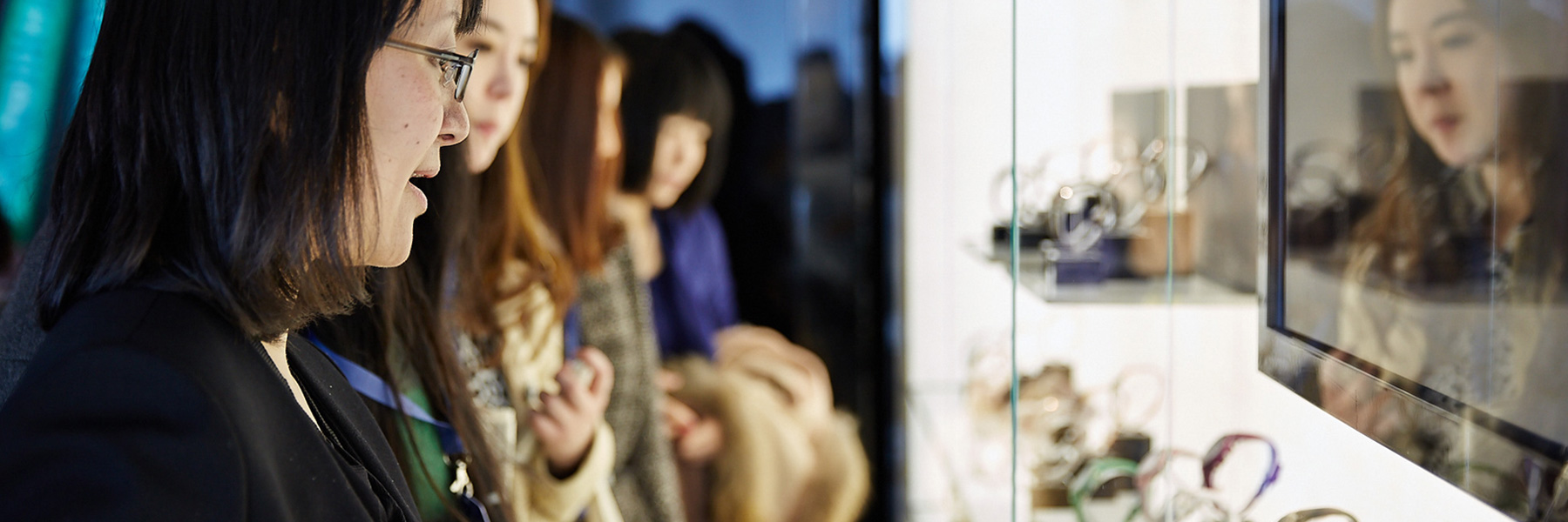 Customer looks at product in Fossil Group showcase booth at Baselworld