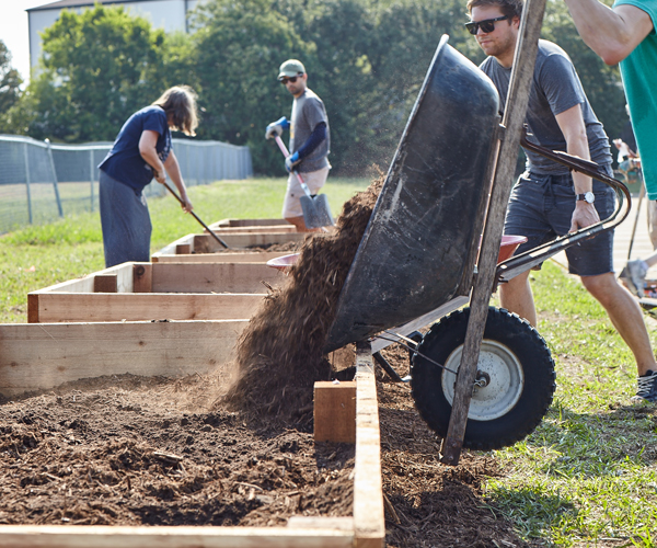Volunteers fill community garden beds at Fossil Group