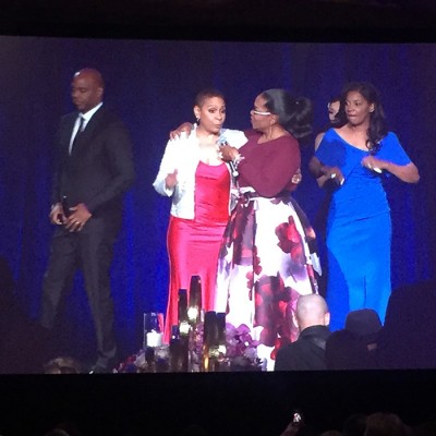 Oprah greets Janiece Evans Page and Steve Evans of Fossil Group on stage at Minnie's Food Pantry Gala 2018