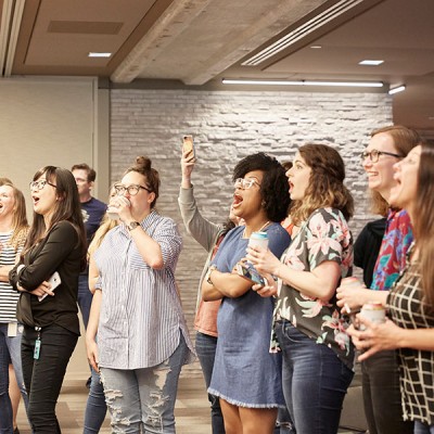 Fossil Group employees watch colleagues play jousting game at annual spring fest