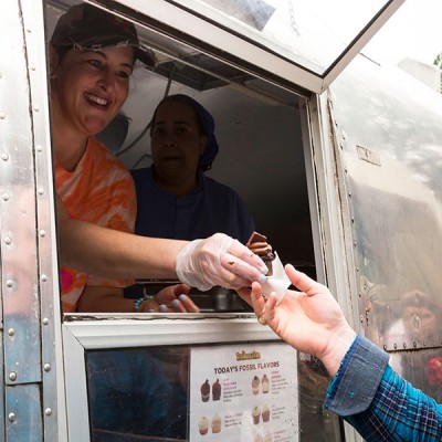 Fossil Group employee gets mini cupcake from TrailerCakes food truck at annual spring fest at Texas headquarters