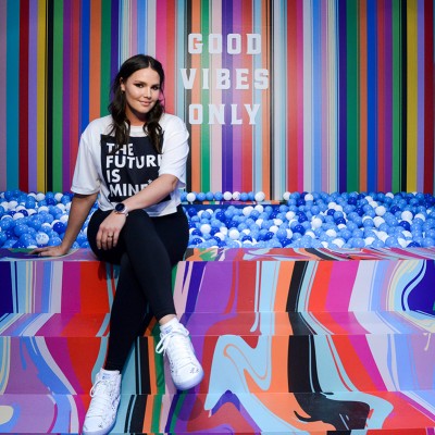 Candice Huffine sits beside ball pit at NYC pop up shop for new Fossil sport smartwatch